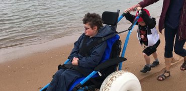 Close up of family using the hippocampe beach wheelchair at Balmedie beach waterfront