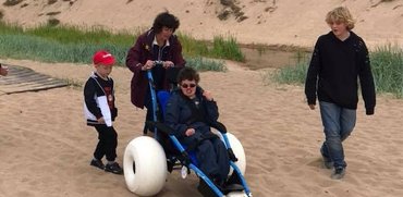 Family using the hippocampe beach wheelchair at Balmedie beach